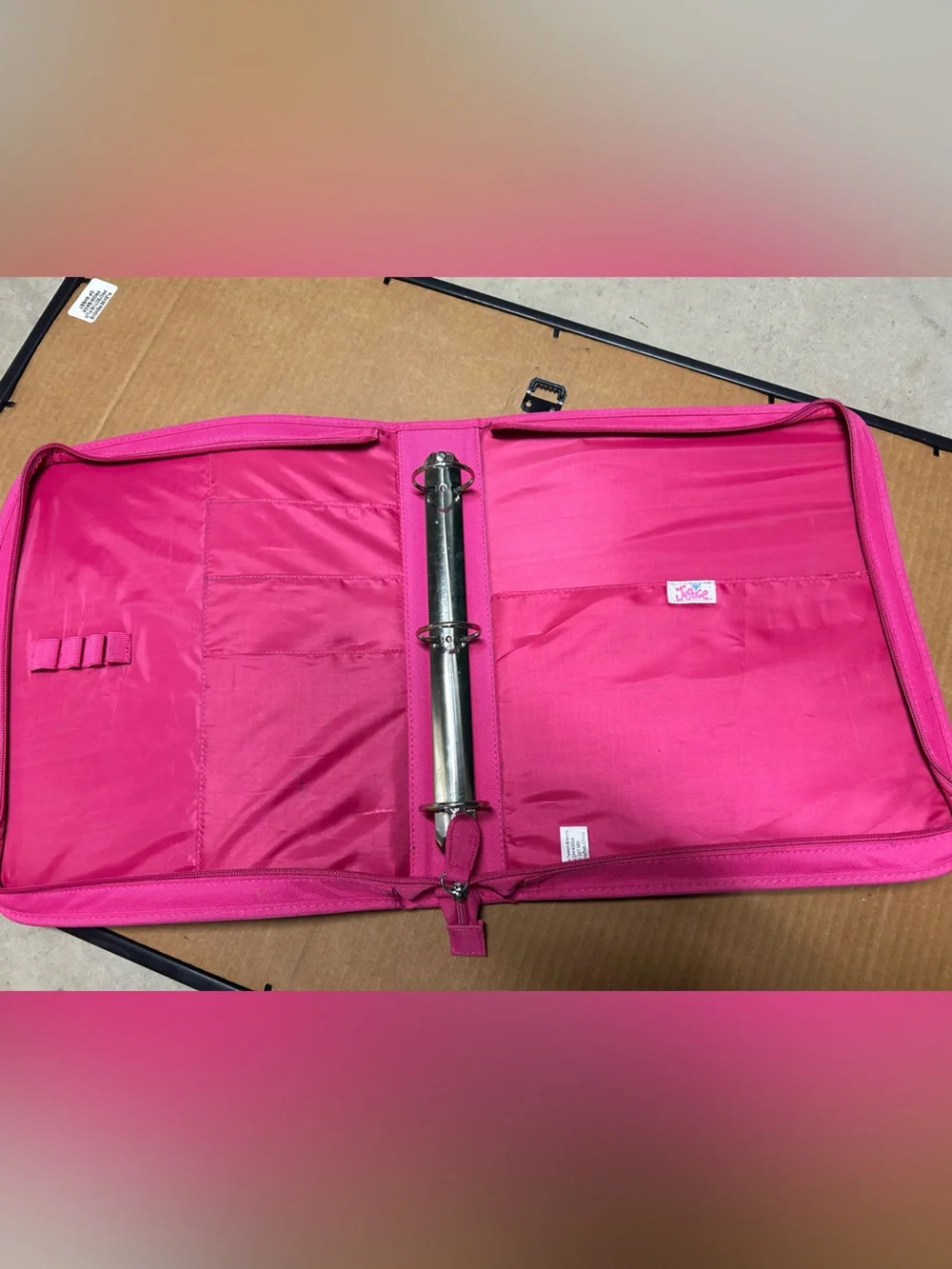 Hot pink, 3 ring binder notebook that zips up and has sequins on the front.